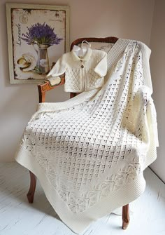 a white crocheted blanket sitting on top of a wooden chair