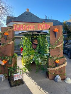 an entrance to a park decorated with fake plants