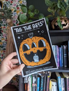 a person holding up a book with an image of a jack - o'- lantern on it