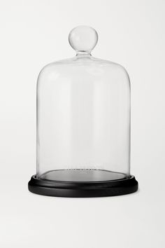 a glass clochet with a black base on a white background, it appears to be empty