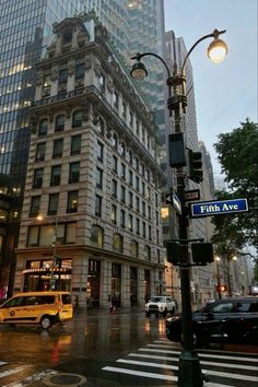 an intersection in the city with traffic and tall buildings on either side, at dusk