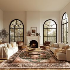 a living room filled with lots of furniture next to two large windows and a fire place