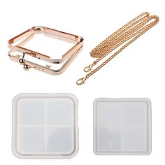 two pieces of clear plastic with gold chains and an apple watch case in the middle