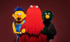 three sesame street characters standing next to each other in front of a red background,