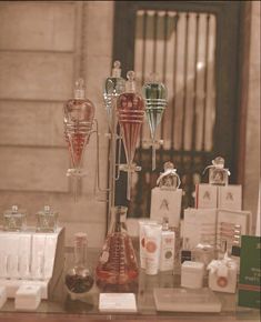 an assortment of perfume bottles on display in front of a window