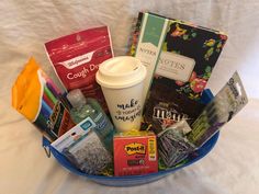 a basket filled with coffee and snacks on top of a bed