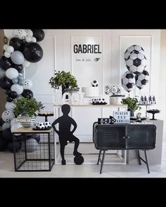 a room filled with black and white balloons, soccer themed decor and decorations on the walls