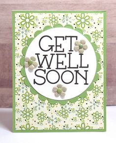 a card with the words get well soon written in black and white on it, surrounded by flowers