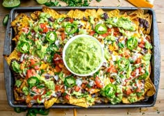 nachos with guacamole and salsa on a tray