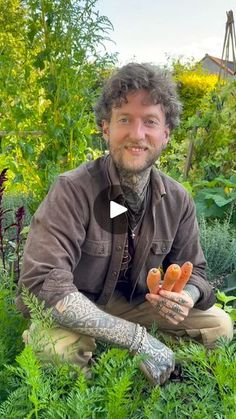 a man kneeling in the grass holding carrots