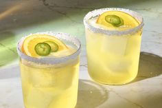 two glasses filled with lemonade and cucumber garnish