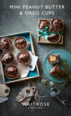 mini peanut butter and oreo cups in a box with tags on the table next to them