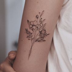 a woman's arm with a flower tattoo on the left side of her arm