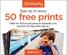 a young boy holding up a camera to take a picture with the sign up for 50 free prints