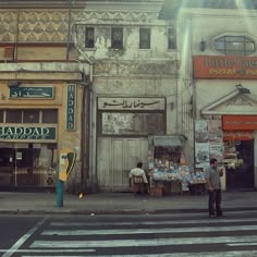 two men are standing on the street corner