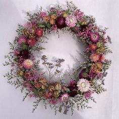 a circular arrangement of flowers arranged in the shape of a wreath on a white background