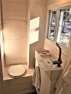 a bathroom with a toilet, sink and window