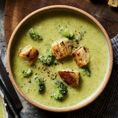 a bowl filled with broccoli soup and croutons