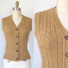 This cute little sweater vest is a caramel tan and features a classic cable-knit pattern. Chocolate brown plastic buttons with a faux-leather pattern. Rib-knit trim on the neckline, armholes, waistband, and placket edges.  Superb vintage condition. Light/minimal surface wear from normal laundering and use. No holes, stains, or other significant damage that we could spot. Branded "Between Stops." 90% acrylic; 10% nylon.  Marked a size large, but please see the following measurements to ensure an Fitted Beige Cable Knit Sweater Vest, Cozy Fitted Cable Knit Sweater Vest, Vintage Brown Sweater With Button Closure, Vintage Brown Sweater Vest For Fall, Brown Buttoned Sweater Vest For Fall, Retro Brown Sweater Vest For Winter, Fall Beige Sweater Vest With Buttons, Vintage Knit Sweater Vest For Fall, Fitted Beige Cozy Sweater Vest