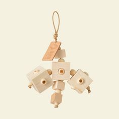 a wooden robot ornament hanging from a string on a white background with a tag attached to it