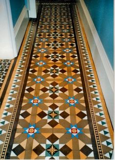 a hallway with blue walls and an ornate tile flooring pattern on the side walk