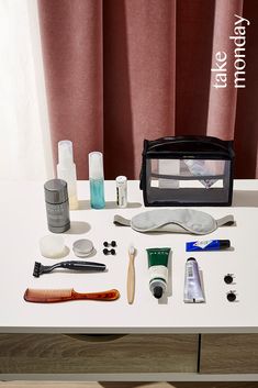 an assortment of personal care items are displayed on a table with a red curtain in the background