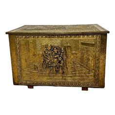 an ornately decorated gold box with figures on it