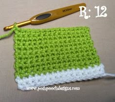 a crocheted green and white dishcloth with a gold handled knitting needle