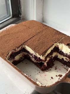 a chocolate cake with white frosting is cut in half