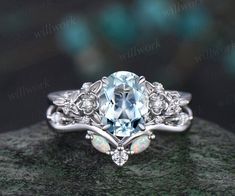 an oval cut aqua blue topazte surrounded by white opal and diamond accents