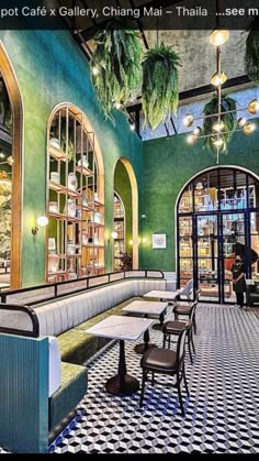 the interior of a restaurant with green walls and black and white checkered flooring