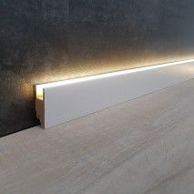 a white wall with a light on it next to a wooden floor and black wall