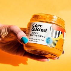 a hand holding a jar of honey on top of a yellow background with the words core & find written in it