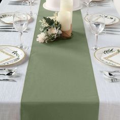 the table is set with white and green place settings