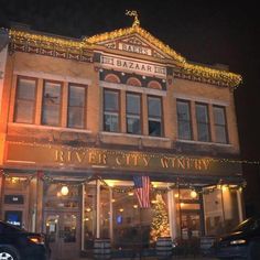 the river city winery is lit up at night with christmas lights on it's windows