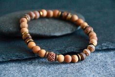 ETHNIC CEDARWOOD BRACELET  This bohemian elegant bracelet features high grade Natural Cedarwood, featuring Rudraksha seeds, Tibetan Dzi beads, as well as Tiger's Eye. This bracelet looks beautiful on its own, or worn together with other gemstone beaded bracelets. You will find more dainty gemstone bracelets here: SEE OUR COLLECTION OF BEADED GEMSTONE BRACELETS: https://www.etsy.com/au/shop/ChandraMalaJewellery?ref=seller-platform-mcnav&section_id=22979611 Beads Size: Natural Cedarwood beads 6mm Dzi beads 6mm Natural Rudraksha seeds 7mm Tiger's Eye Golden elements 6-7mm This bracelet was fashioned on strong professional jewellery elastic for quality and durability.    Length: This bracelet is 18 cm long = 7" for the women's size and 20.5cm = 8" for the men's size- it is a medium size that w Bohemian Round Beaded Bracelets For Everyday, Bohemian Beaded Bracelets For Everyday, Bohemian Everyday Beaded Bracelets, Bohemian Bracelets With 8mm Round Beads, Natural Jewelry, Professional Jewelry, Gemstone Beaded Bracelets, Elegant Bracelet, Stretchy Bracelets