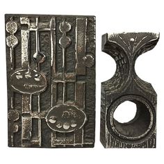 two pieces of art that are made out of metal and have different designs on them