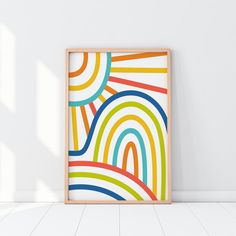 an abstract painting in a wooden frame against a white wall