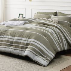 a bed with green and white striped comforter