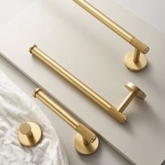 two brass handles on a white surface