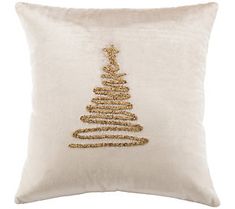 a white pillow with a gold christmas tree embroidered on it