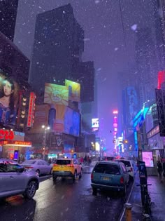 a city street filled with lots of traffic on a snowy day in the rain at night