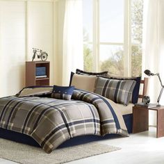 a bed with plaid comforter and pillows in a room