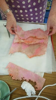 a woman is cutting up some meat on a piece of paper with a pair of scissors