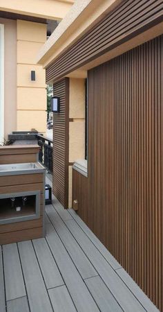 an outdoor bbq with grills on the side of it and wooden flooring