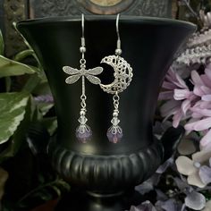 Dragonfly and moon filagree drop earrings with purple stones.  The silver moon and dragonfly components used to make these earrings are sterling silver plated brass from USA.  The drop is a Swarovski Cyclamen Opal and a clear bead. The earrings are finished and pictured with a stainless steel Fish Hook. There is an option to change to small lever-back if preferred, they are all stainless steel. Total drop of these earrings is approx. 55mm, measured from the top of the earring hook. ♦︎ DRAGONFLY Elegant Purple Earrings For Festival, Elegant Silver Dangle Jewelry, Purple Drop Earrings For Festival, Mystical Drop Earrings For Festival, Vintage Wire Wrapped Dangle Jewelry, Purple Festival Jewelry With Ear Wire, Nickel Free Crystal Drop Earrings For Festival, Bohemian Sterling Silver Crystal Earrings Nickel Free, Silver Dangle Crystal Earrings For Festivals