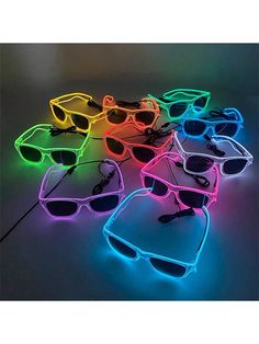 neon glasses with sunglasses attached to them are all lined up together on the floor and one is