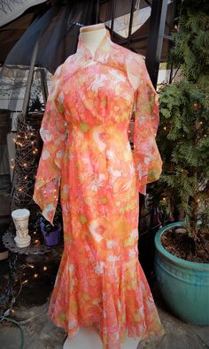 "Vtg 1960's Orange Pink Green Floral Grecian Style Full Length Nylon Dress & Scarf sz S/6 This is a lovely vintage dress I picked up recently in New England. It's a bright sheer nylon fabric in orange, pink, and green. It is a Grecian off the shoulder style. This dress is fully lined. The bottom of the dress has beautiful triangular inserts. There is a back zipper here as well. I believe this dress is hand made and it is nicely done. There is a beautiful scarf that goes along with the dress Spring Mid-century Dresses For Vintage Events, Retro Vintage Dress For Spring Events, Mid-century Dresses For Spring Vintage Events, Spring Party Dress With Vintage Print, Retro Sheer Summer Dress, 1970s Vintage Summer Party Dress, Retro Fitted Sheer Dresses, Vintage Orange Dress For Garden Party, Vintage Floral Print Midi Dress For Party