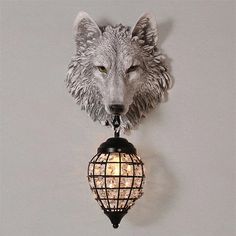 a wolf head mounted to the side of a wall next to a light fixture with lights on it