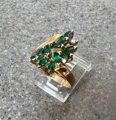 "Ladies' 14K Yellow Gold Emerald Diamond Ring by Effy This listing is for a Ladies' 14K Emerald Ring. This eye catching ring features 11 marquis cut emeralds of a vibrant and vivid hue, with two shiny diamonds nestled in the cluster. The ring is 4.2 grams of 14k yellow gold and is stamped \"14K\" and \"BH\". The ring is size 6.75  and and is capable of being re-sized. It is in good condition. Will ship in a gift box:-) Stock # R1398 As with all jewelers, I do enlarge pictures of the jewelry.  This is to your advantage, so you can see all details more clearly.  I do provide measurements of the jewelry, so be sure to read the description to better understand the true size of the item. Please review the measurements carefully.  I recommend grabbing a ruler or tape measure and visualizing the Marquise Emerald Ring For May Birthstone, Fine Jewelry Marquise Emerald Ring With 17 Jewels, Vintage Green Marquise Emerald Ring, 14k Gold Marquise Cut Emerald Ring, Emerald Gem, Emerald Diamond Ring, Pearl Earrings Dangle, Ruby Diamond, Diamond Drops